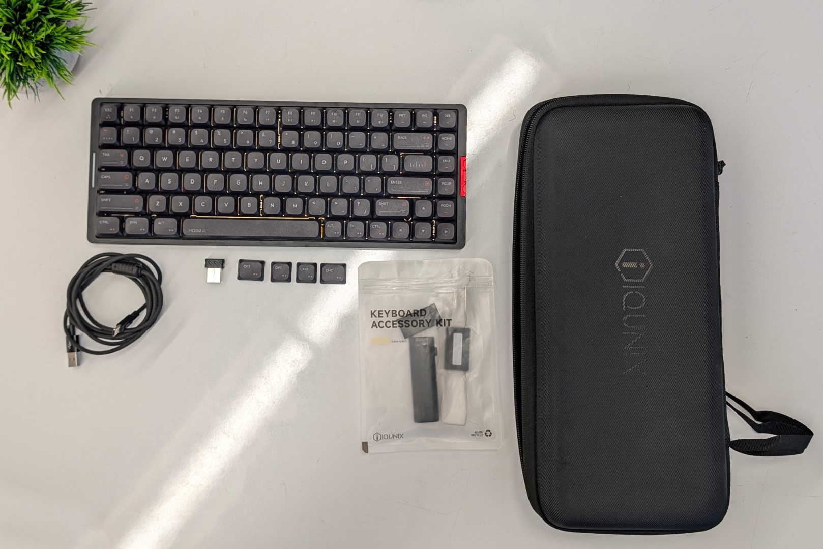 Алюминиевая низкопрофильная клавиатура IQUNIX MQ80 рядом с чехлом для переноски